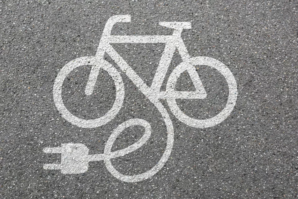 White electric bike logo on asphalt